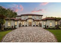 Stunning two-story home showcasing a tile roof and large brick driveway at 11019 Kentmere Ct, Windermere, FL 34786