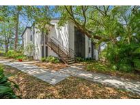 Exterior view of a two-story condo building with stairwell access and mature landscaping at 150 Waterfall Way # 102, Altamonte Springs, FL 32714