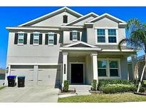 Two-story home with a two-car garage, well-manicured lawn, and mature trees at 18219 Oliver Twist Way, Winter Garden, FL 34787