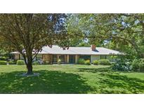 Charming single story home with a metal roof, brick accents, and mature landscaping in a park-like setting at 203 E Greentree Ln, Lake Mary, FL 32746