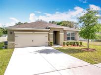 Charming single-story home featuring a well-manicured lawn, fresh landscaping, and an attached two-car garage at 2636 Grand Central Ave, Tavares, FL 32778