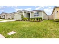 Charming one-story home featuring a well-manicured lawn and a neatly landscaped garden bed at 4351 Finch Ln, Kissimmee, FL 34746