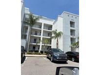 Modern condo building with multiple stories, balconies, and parking spaces for residents and visitors at 4751 Clock Tower Dr # 103, Kissimmee, FL 34746