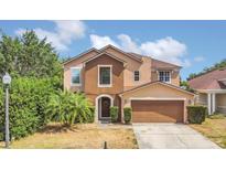 Charming two-story home showcasing neutral tones, arched entryway and a well-manicured lawn at 5056 Gandross Ln, Mount Dora, FL 32757