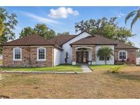 Charming single-story home with stone accents, a well-manicured lawn, and a welcoming entrance at 841 Oaks Shores Rd, Leesburg, FL 34748