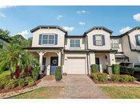 Charming townhome with blue shutters, a brick walkway, and a one car garage at 10404 Park Commons Dr, Orlando, FL 32832