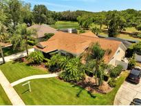 Charming single-story home with lush landscaping, mature trees, and a well-maintained lawn near a beautiful lake at 1121 Arbor Glen Cir, Winter Springs, FL 32708