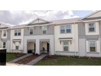 Charming townhome with inviting entryway and manicured landscaping on a sunny day at 1264 Blue Island Dr, Clermont, FL 34714