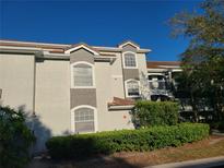 Condo exterior featuring a white stucco facade, gray accents, multiple windows, and a private balcony at 14001 Fairway Island Dr # 513, Orlando, FL 32837
