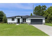Charming single-story home with a well-maintained lawn and a two-car garage at 14470 Sw 46Th Ct, Ocala, FL 34473