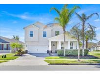 Charming two-story home with a well-manicured lawn and lovely palm trees at 14518 Black Quill Dr, Winter Garden, FL 34787
