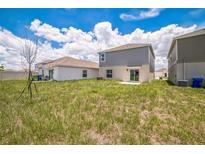 View of the home's backyard, featuring the lawn and the exterior of the house at 264 Hayley St, Winter Haven, FL 33884