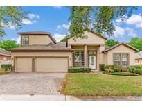 Charming two-story home with a three-car garage, well-manicured lawn, and beautiful landscaping at 902 Hire Cir, Ocoee, FL 34761