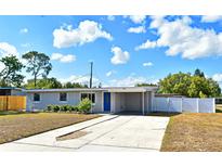 Charming single-story home featuring a well-manicured lawn, blue door, and a convenient carport at 994 Lormann Cir, Longwood, FL 32750