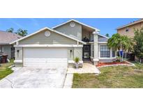 Charming single Gathering home featuring an attached garage, manicured lawn, and inviting curb appeal at 1021 Whalebone Bay Dr, Kissimmee, FL 34741
