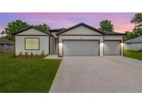 Charming home featuring a two-car garage, inviting facade, and manicured lawn at 13312 Sw 41St Ct, Ocala, FL 34473