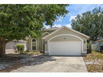 Charming one-story home featuring an attached two car garage and mature landscaping at 135 Andrews Rd, Sanford, FL 32773