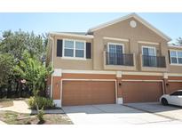 Townhouse with brown garage doors, beige siding, and small balconies at 2530 San Jacinto Cir # 2530, Sanford, FL 32771