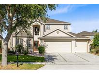 Two-story home with a three car garage, mature trees and landscaping in the front yard at 2704 Gorst Rd, Winter Garden, FL 34787
