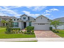 Charming single-Gathering home showcasing a brick driveway, meticulously maintained landscaping, and an attached two-car garage at 4296 Mirror Ct, Clermont, FL 34714