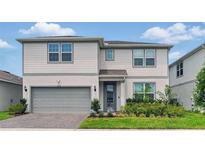Charming two-story home with a manicured lawn, beautiful landscaping and gray siding at 4336 Foggy Oak Ln, Sanford, FL 32773