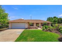 Charming single-story home featuring a well-maintained lawn and an attached two-car garage at 8702 Master Link Ct, Orlando, FL 32836