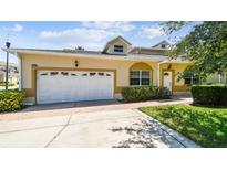 Inviting home with a two-car garage, well-maintained lawn, and a welcoming entrance at 13241 Fountainbleau Dr, Clermont, FL 34711