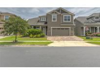 Inviting two-story home featuring a well-manicured lawn and a brick paved driveway leading to a two car garage at 3302 Stonegate Dr, Ocoee, FL 34761