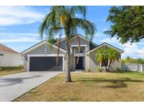 Charming single-story home with a well-maintained lawn, gray exterior, and a two-car garage at 119 Argyle Gate Loop Rd, Dundee, FL 33838