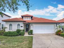 Charming single-story home featuring a red tile roof, arched windows, and a well-manicured lawn at 16604 Caribbean Breeze Way, Clermont, FL 34714