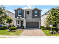 Charming two-story home features a two-car garage, brick paver driveway, and inviting covered porch at 2264 Emerald Springs Dr, Apopka, FL 32712
