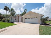 Charming single-story home featuring a two-car garage, well-manicured lawn and mature palm trees, located in a serene neighborhood at 23 Old Sunbeam Dr, South Daytona, FL 32119