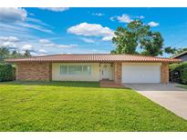 Charming single-story home with a well-maintained lawn, brick accents, and a neutral-colored exterior under a blue sky at 3108 Troy Dr, Orlando, FL 32806