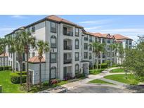 Attractive condominium building with private balconies, tile roof and tropical landscaping at 4024 Breakview Dr # 40604, Orlando, FL 32819
