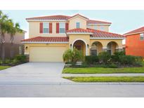 Charming two-story home featuring a red tile roof, neutral exterior, and a well-maintained front lawn at 4405 Acorn Ct, Davenport, FL 33837