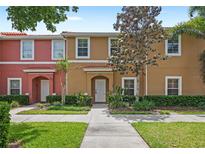 Charming townhome featuring colorful facade, well-maintained landscaping, and inviting entryway at 3064 Yellow Lantana Ln, Kissimmee, FL 34747