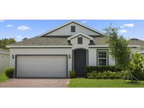 Charming single-story home featuring a brick driveway, two-car garage, and neatly landscaped front yard at 451 Shadow Gorge Way, Eustis, FL 32736