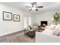 Cozy living room with white brick fireplace, ceiling fan, and French doors leading to the outside at 577 Compton Ct, Deland, FL 32724