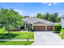 Well maintained single story home featuring a 3-car garage and manicured lawn at 721 Lake Cove Pointe Cir, Winter Garden, FL 34787