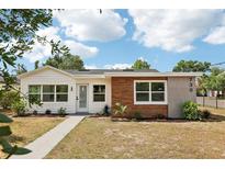 Charming single-story home boasting a mix of modern wood and white siding, manicured lawn, and inviting curb appeal at 730 W Swoope Ave, Winter Park, FL 32789
