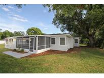 Cozy home exterior featuring a screened porch and nicely landscaped yard at 1016 E Fillmore Ave, Orlando, FL 32809