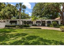 Charming single-story home with well-manicured landscaping, brick driveway, and inviting front entrance at 2105 Fosgate Dr, Winter Park, FL 32789