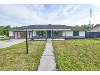 Charming single-story home featuring a landscaped front yard and a welcoming entrance with decorative stone accents at 211 Marion Oaks Ln, Ocala, FL 34473