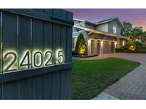 Elegant home exterior featuring illuminated address numbers, manicured lawn, and three-car garage at 2402.5 Temple Dr, Winter Park, FL 32789