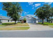 Charming single-story home featuring a well-manicured lawn, mature trees, and inviting curb appeal at 2709 Prestwick Ln, Kissimmee, FL 34744