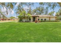 Well-manicured front yard with lush green grass and tropical plants complementing the charming single-story home at 334 Terrace Dr, Oviedo, FL 32765