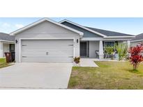 Charming single-story home featuring a well-manicured lawn, attached garage, and covered entryway at 4215 Swan St, Haines City, FL 33844