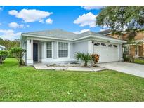 Charming single-story home with a well-maintained lawn, updated facade, and an attached two-car garage at 4347 Creekside Blvd, Kissimmee, FL 34746
