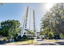 Stunning high-rise condo building showcasing modern architecture and lush landscaping on a sunny day at 530 E Central Blvd # 1702, Orlando, FL 32801
