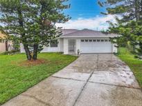 Charming single-story home with a well-maintained lawn, mature trees, and a two-car garage at 5481 Nokomis Cir, Orlando, FL 32839